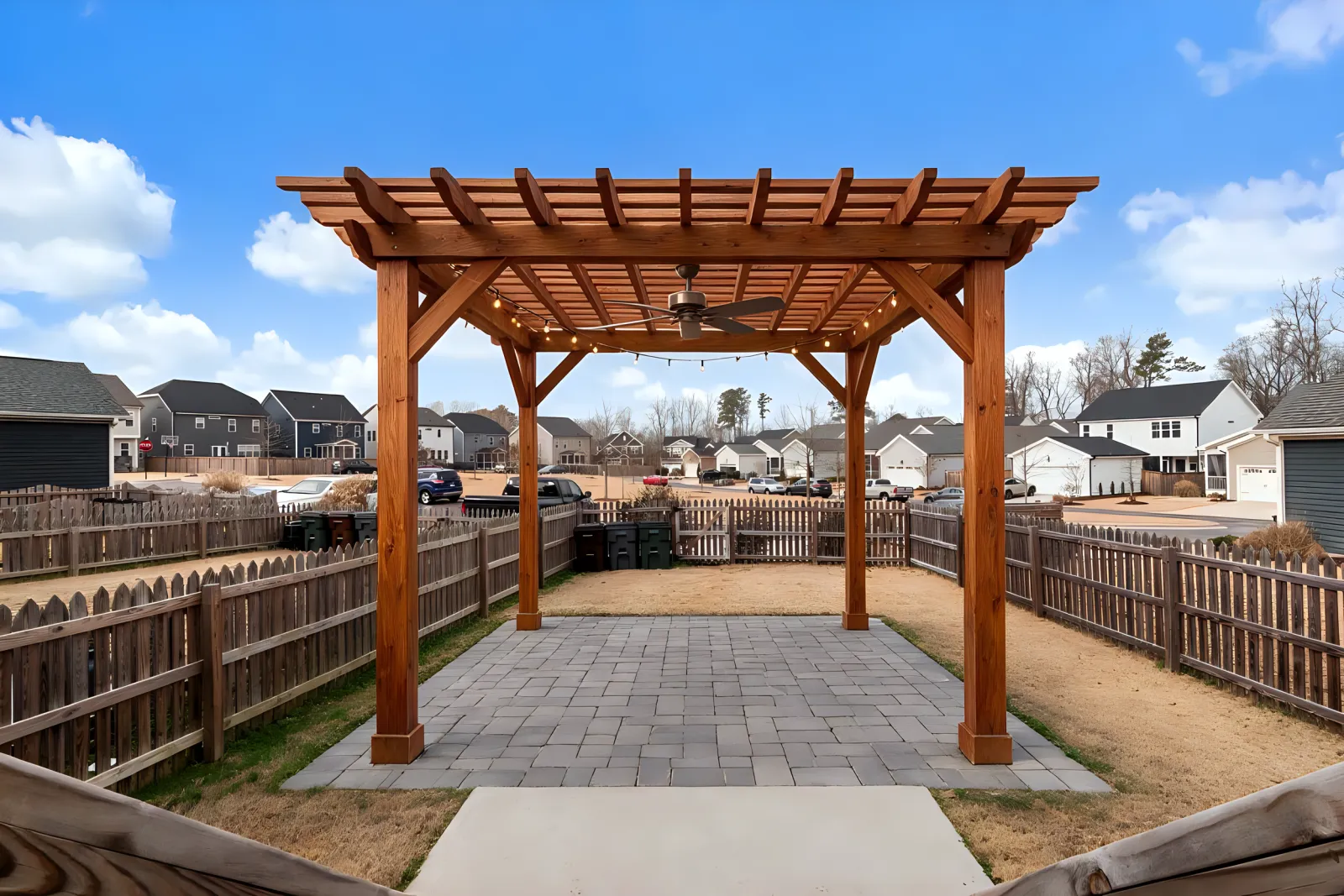 The same yard with an AI-designed cedar pergola over pavers
